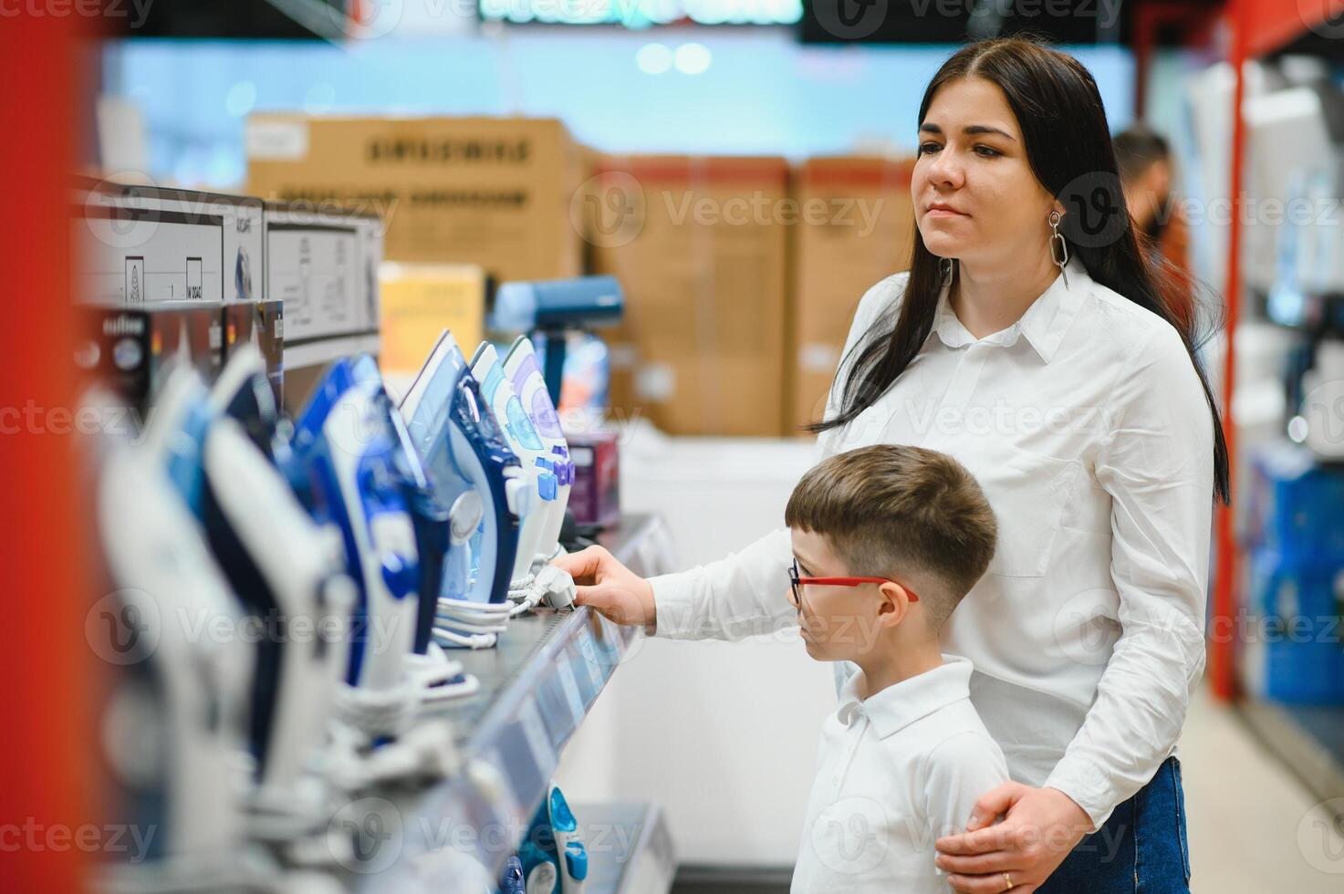 mujer con hijo elegir eléctrico hierro en electrónica Tienda foto