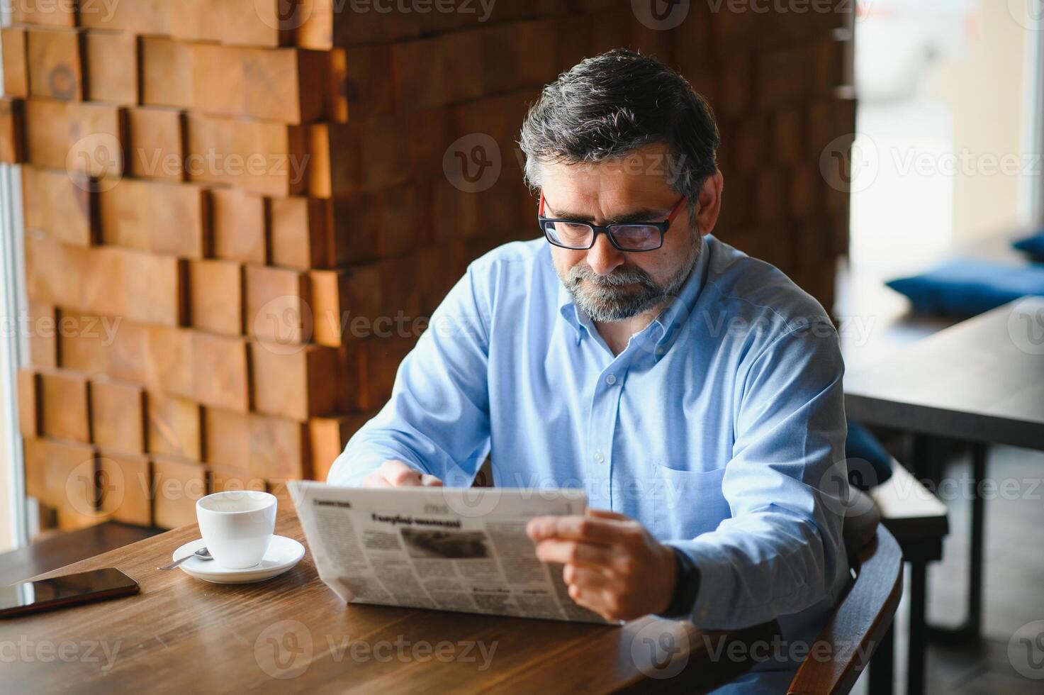 coffee break. man drinking coffee and reading newspaper in cafe bar photo