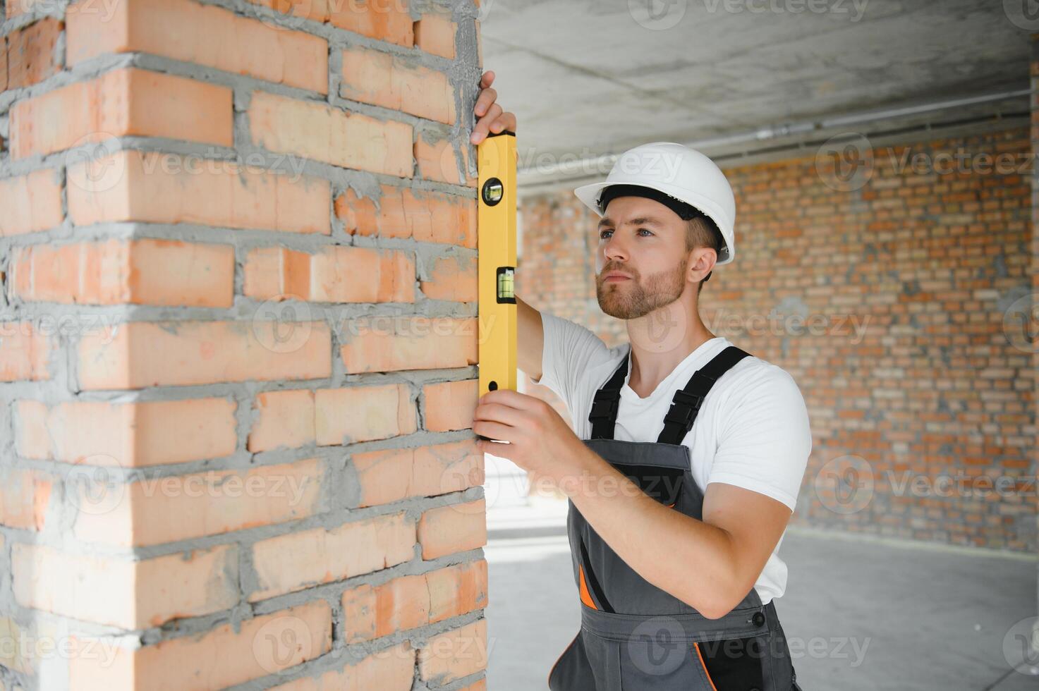 Portrait of handsome male builder in overalls and hard hat photo