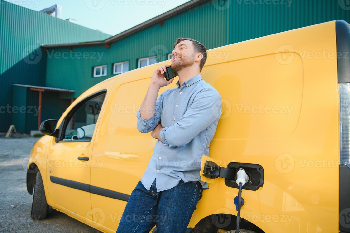 hermoso hombre utilizando teléfono mientras coche siendo cargado foto