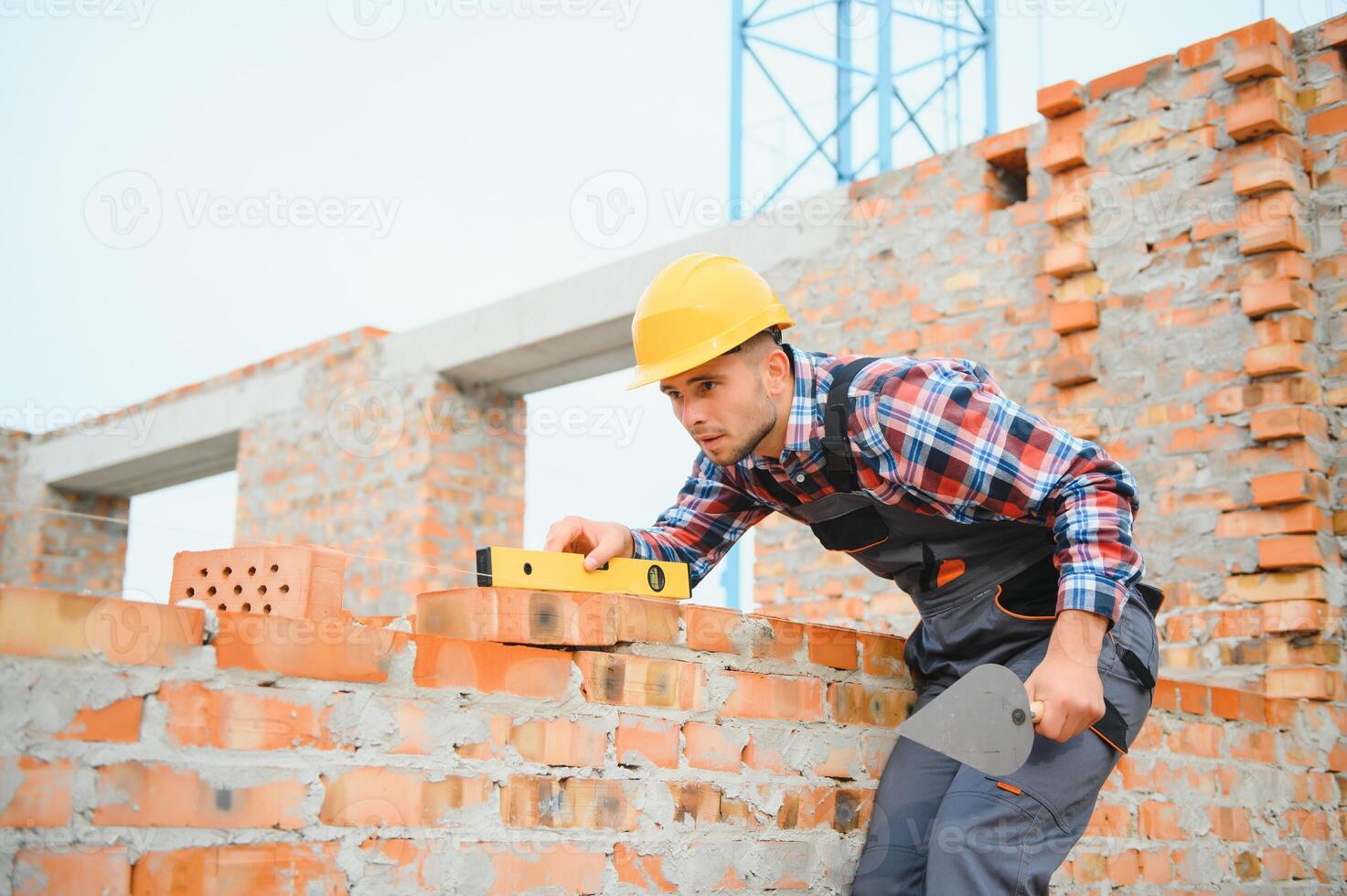Busy with brick wall. Construction worker in uniform and safety equipment have job on building. photo