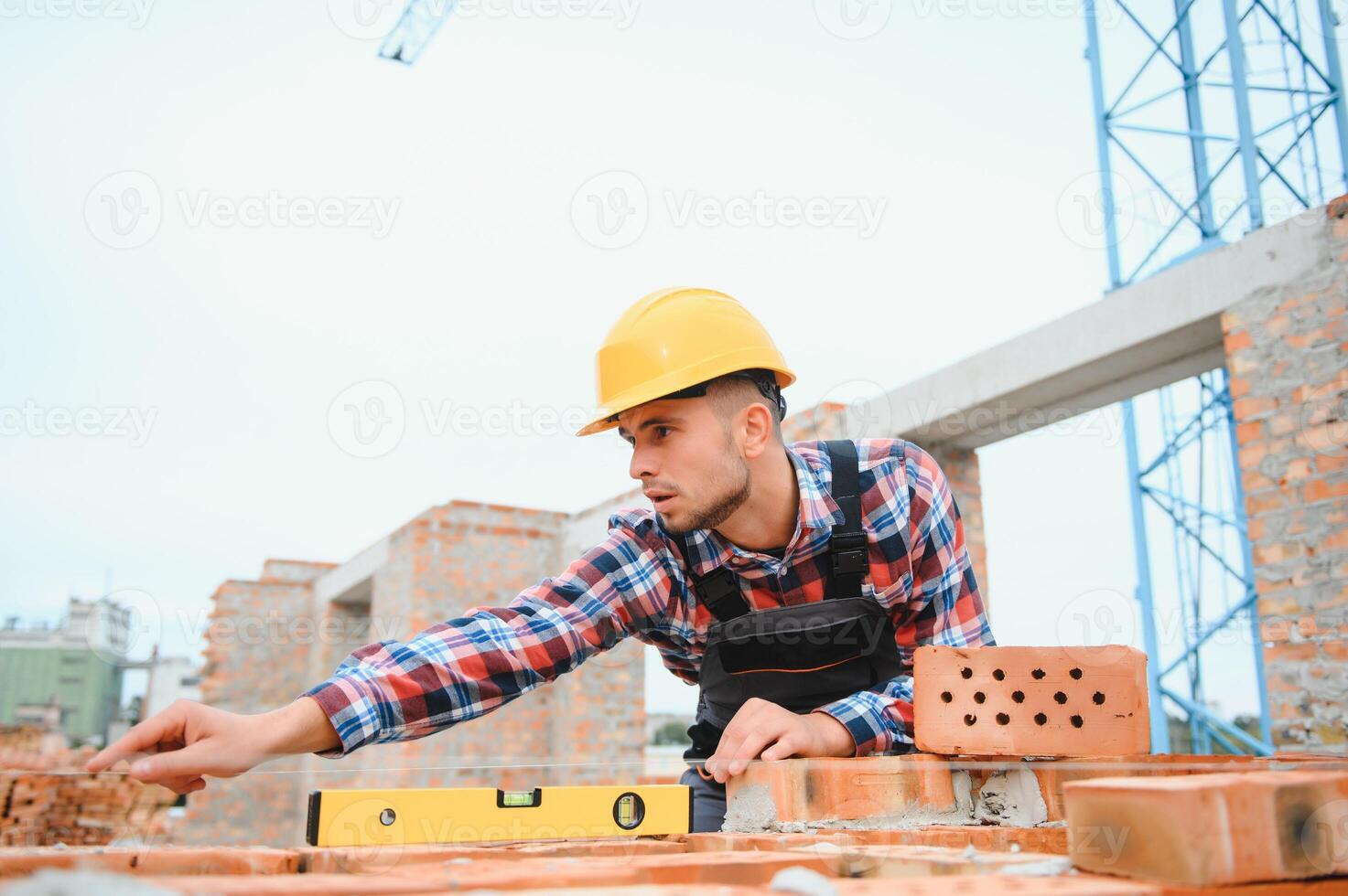 Busy with brick wall. Construction worker in uniform and safety equipment have job on building. photo
