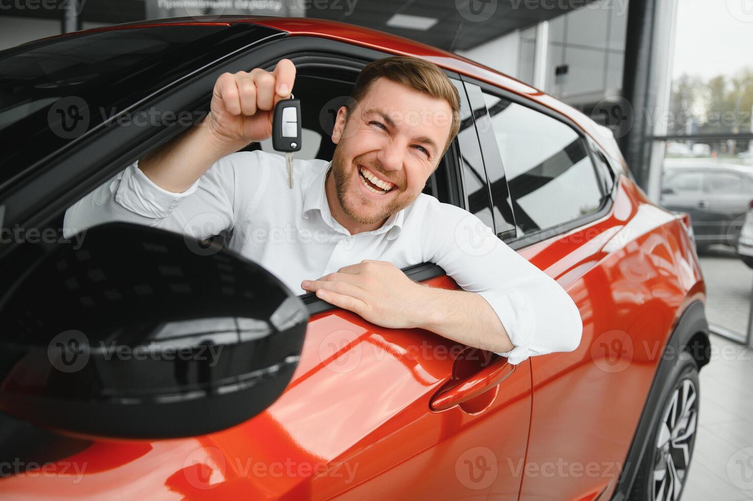 Happy man showing the key of his new car. photo