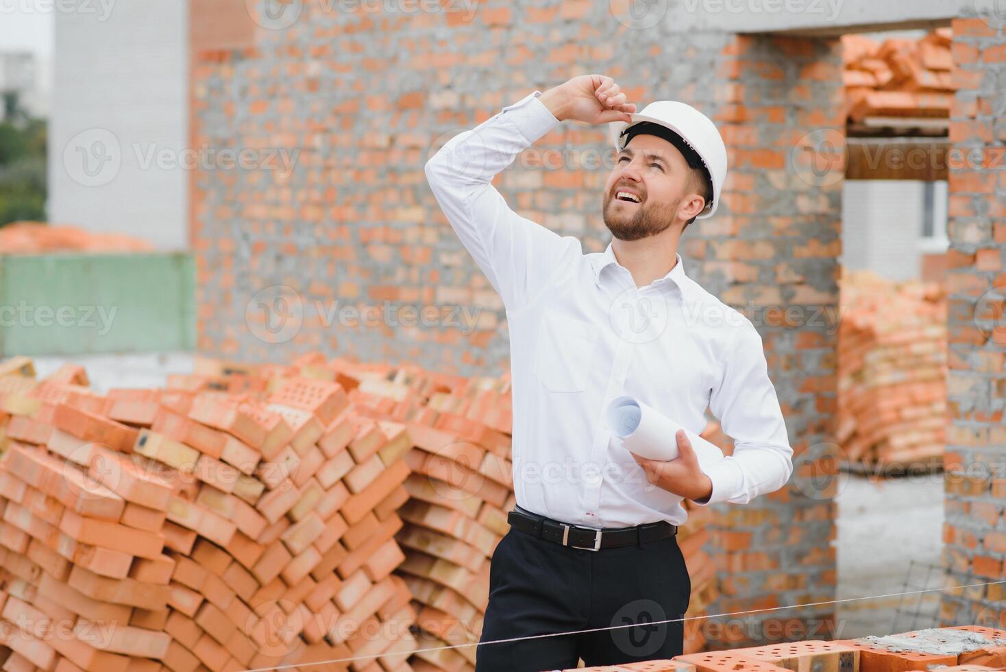 Architect at a construction site with blueprints photo