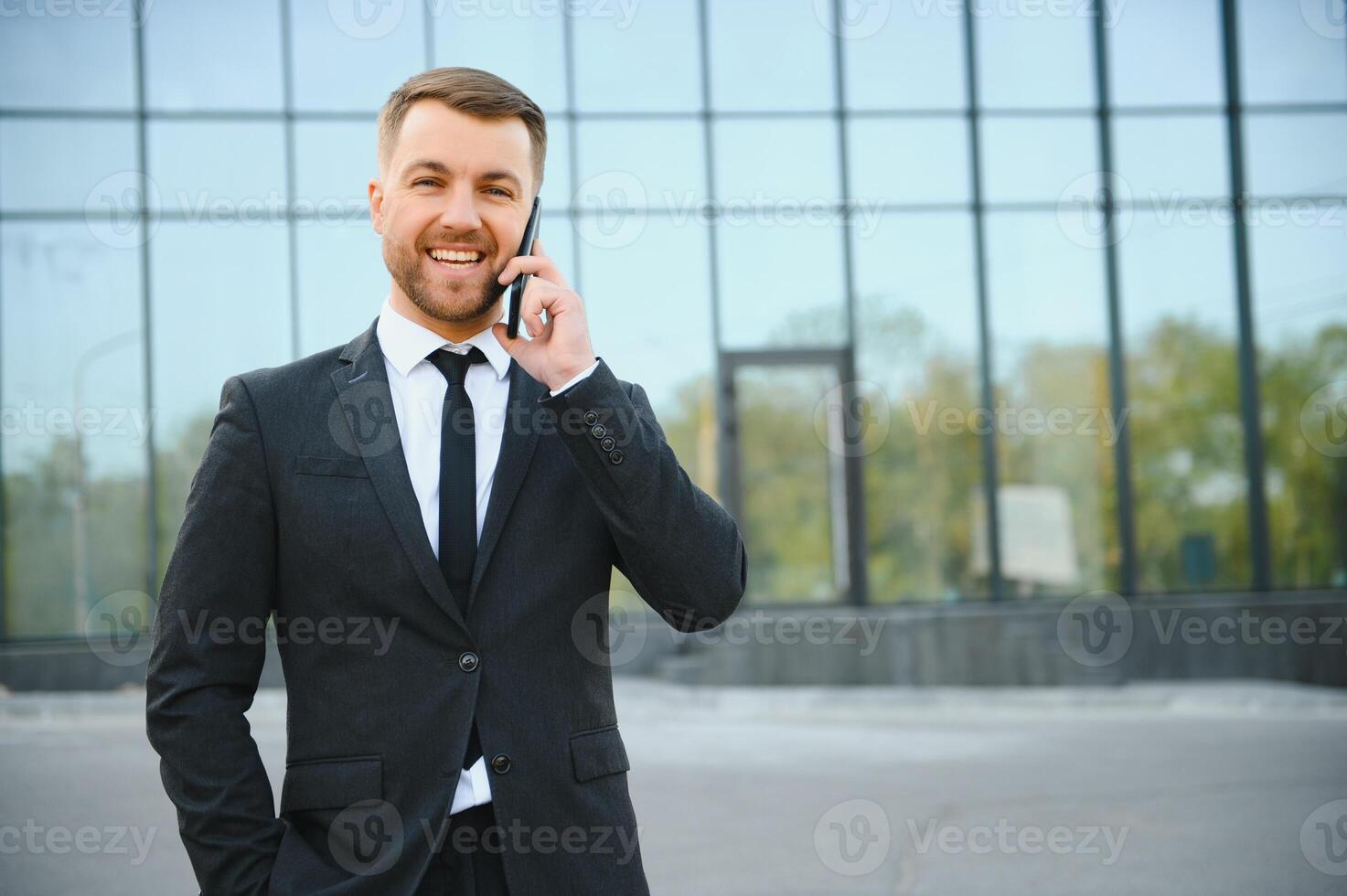 Businessman using smartphone in covered walkway. photo