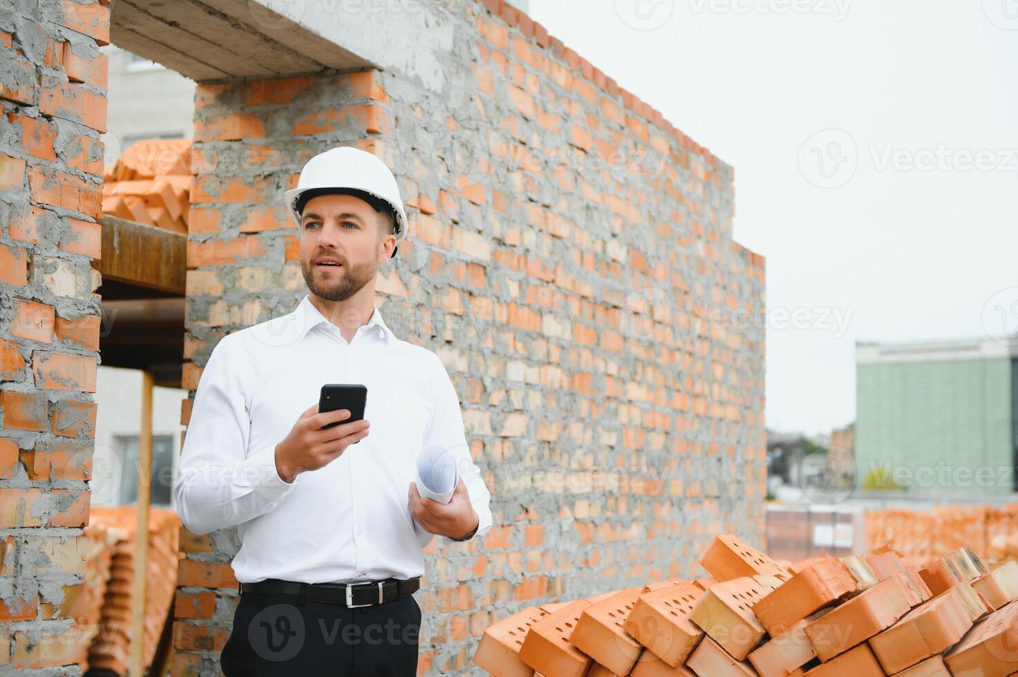 Architect at a construction site with blueprints photo