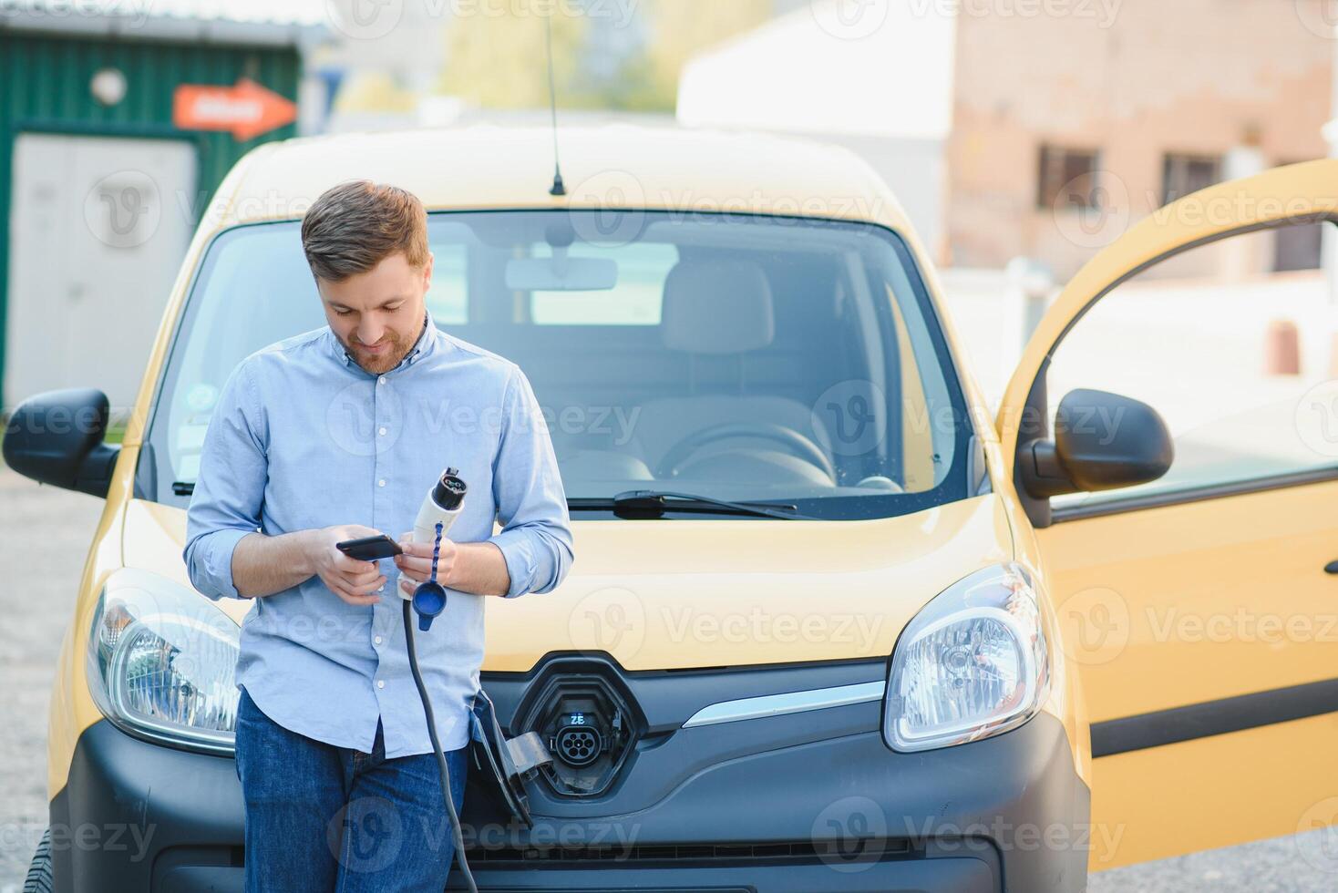 Man charging his electric car at charge station. photo