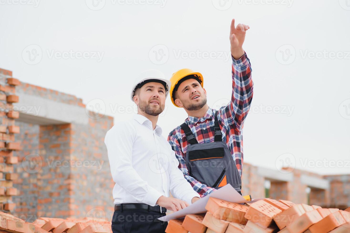 Structural engineer and foreman worker discuss, plan working for the outdoors building construction site photo