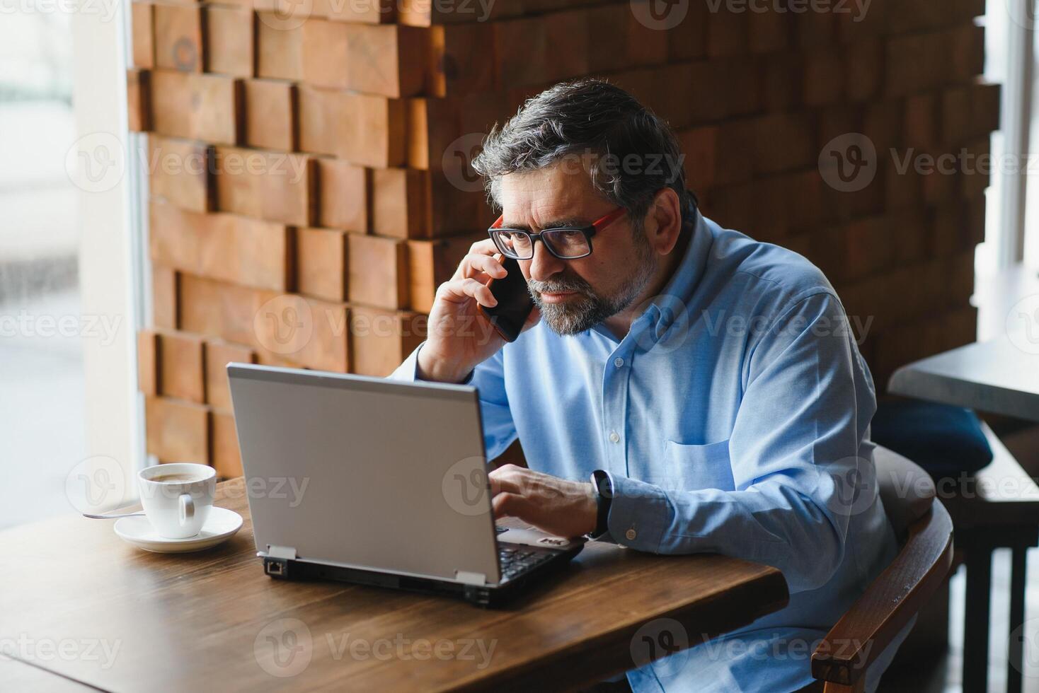 Business, technology and people concept , senior businessman with laptop computer drinking coffee at modern cafe. photo