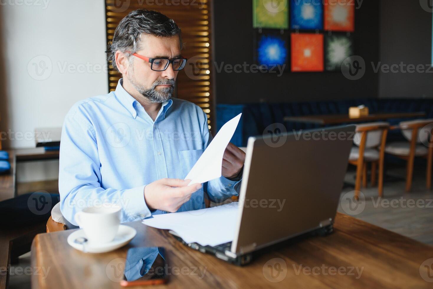 Business, technology and people concept , senior businessman with laptop computer drinking coffee at modern cafe. photo