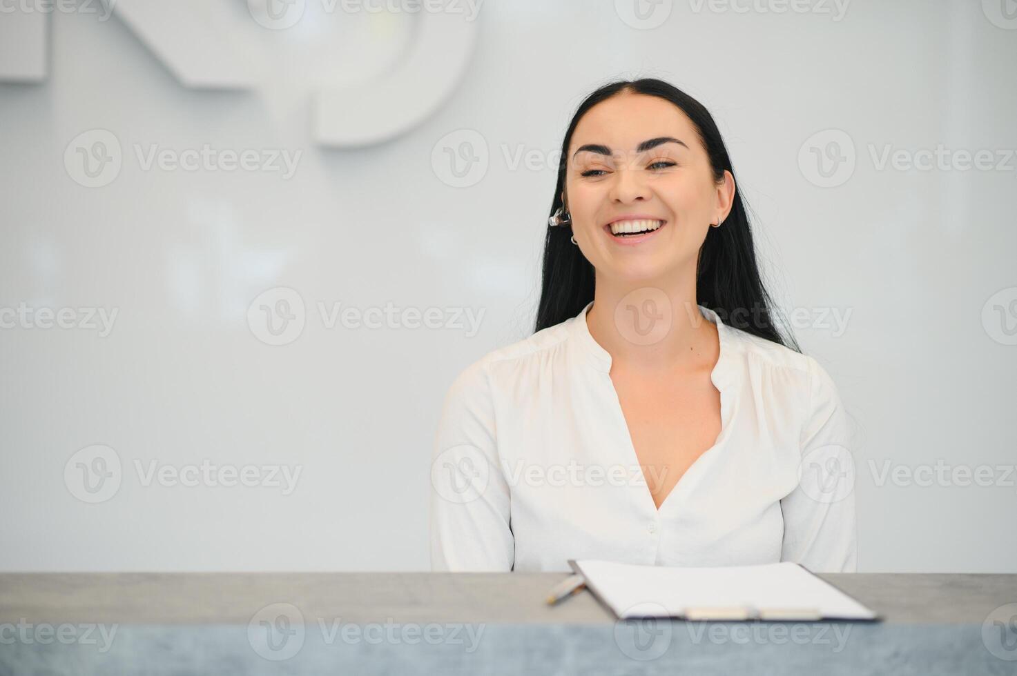 Portrait of beautiful receptionist near counter in hotel photo