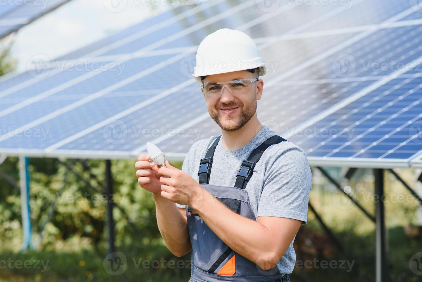 A man holds an Incandescent light bulb in his energy concept, the sun is clean after work and replaces the energy that produces carbon dioxide. photo