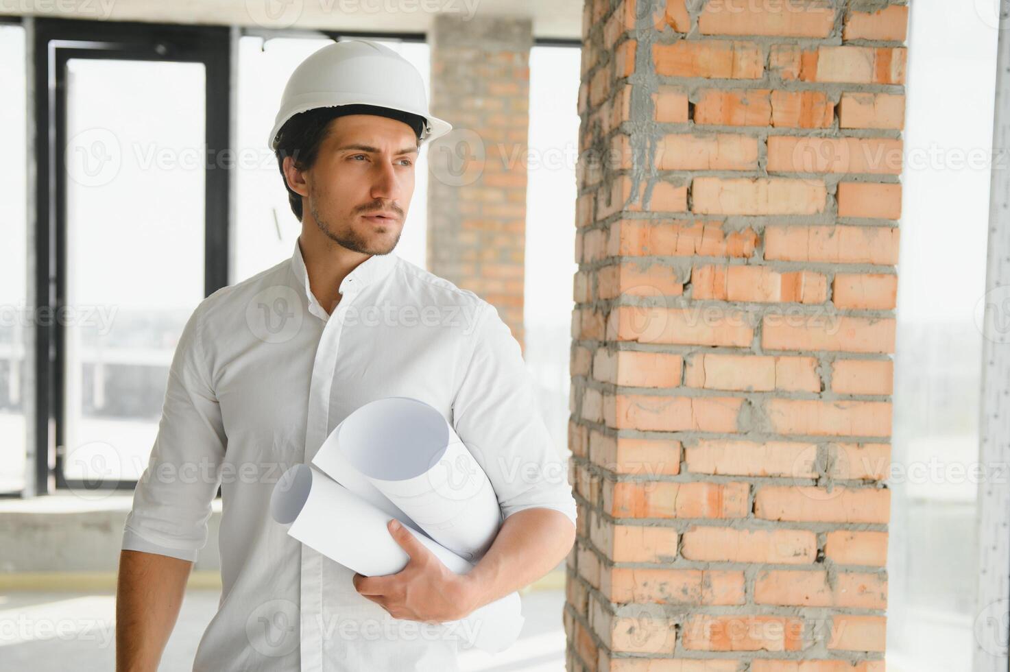Business architect man wearing hardhat standing of a building project photo