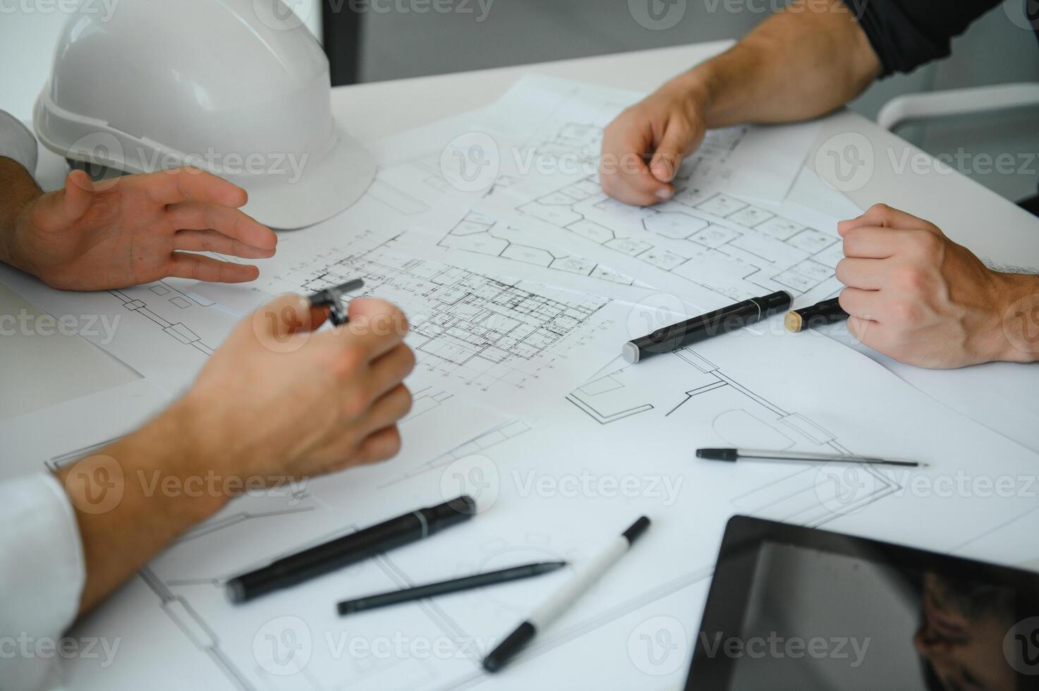 two people sit in front of construction plan and talk about the architecture photo
