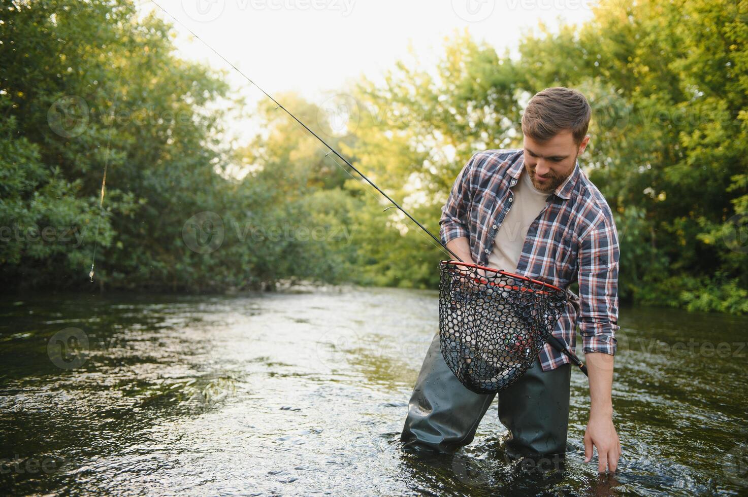 Trout fishing on mountain river photo