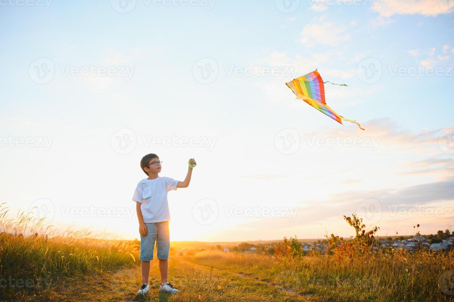 niños lanzamiento un cometa en el campo a puesta de sol. foto