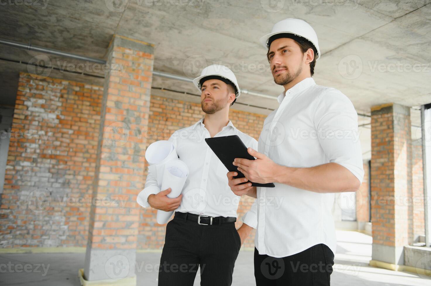 Male Architect Giving Instructions To His Foreman At Construction Site. photo
