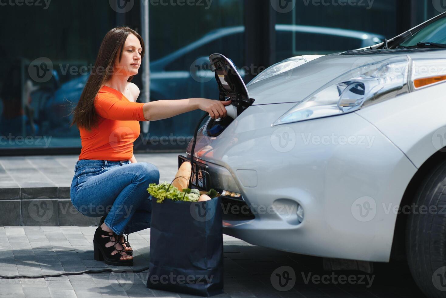 mujer es cargando alquiler eléctrico coche foto
