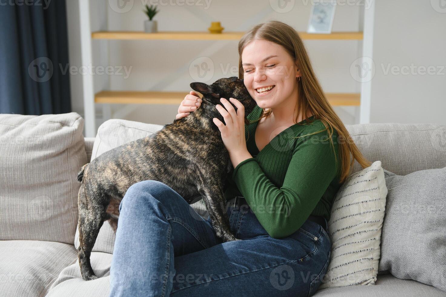 Female owner playing with joyful dog at home. Playing with dog concept photo
