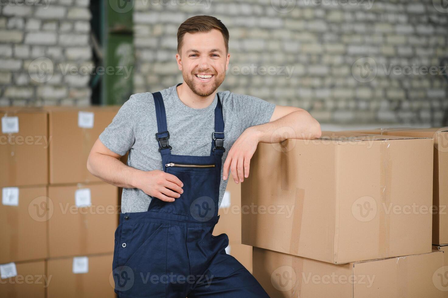 almacén trabajador que lleva un caja de cartón para entrega a producción existencias. foto