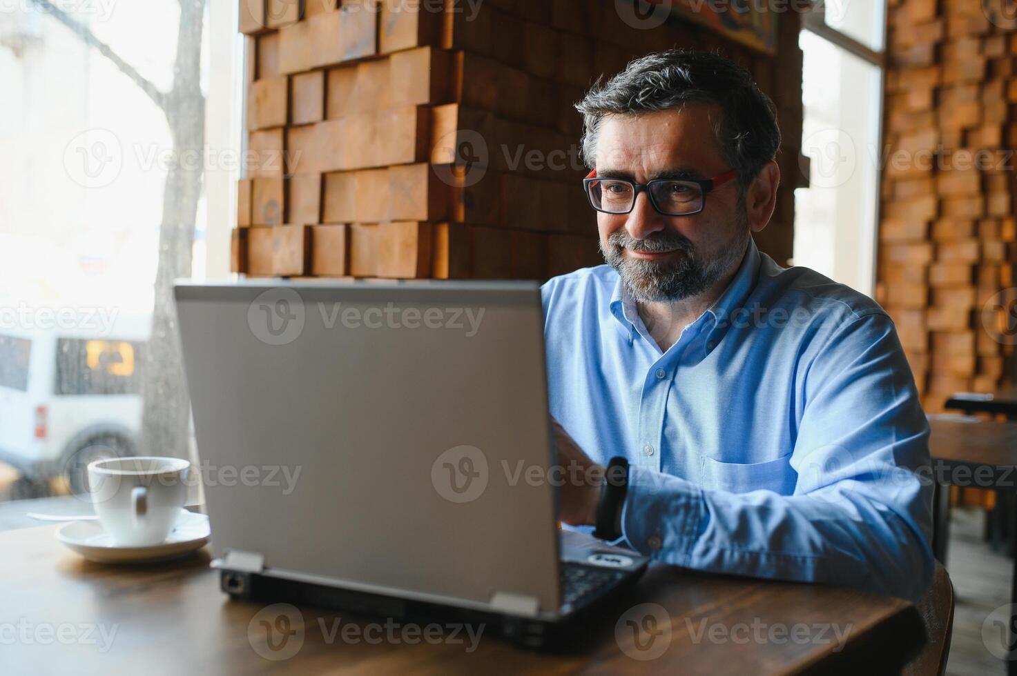 Business, technology and people concept , senior businessman with laptop computer drinking coffee at modern cafe. photo