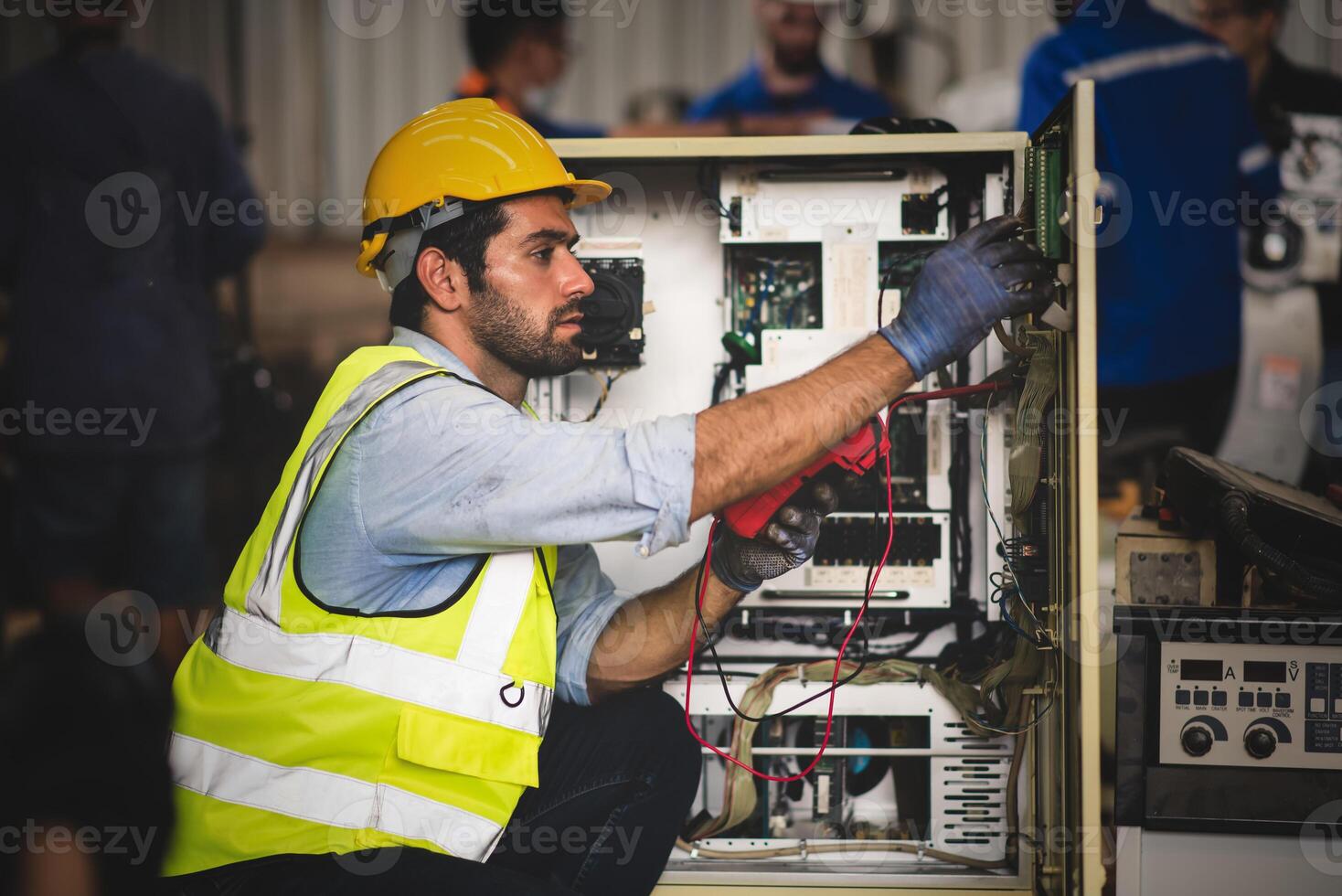 eléctrico ingeniero trabajo ensayador medición voltaje y Actual de poder eléctrico línea en eléctrico gabinete controlar para industrial producción. foto