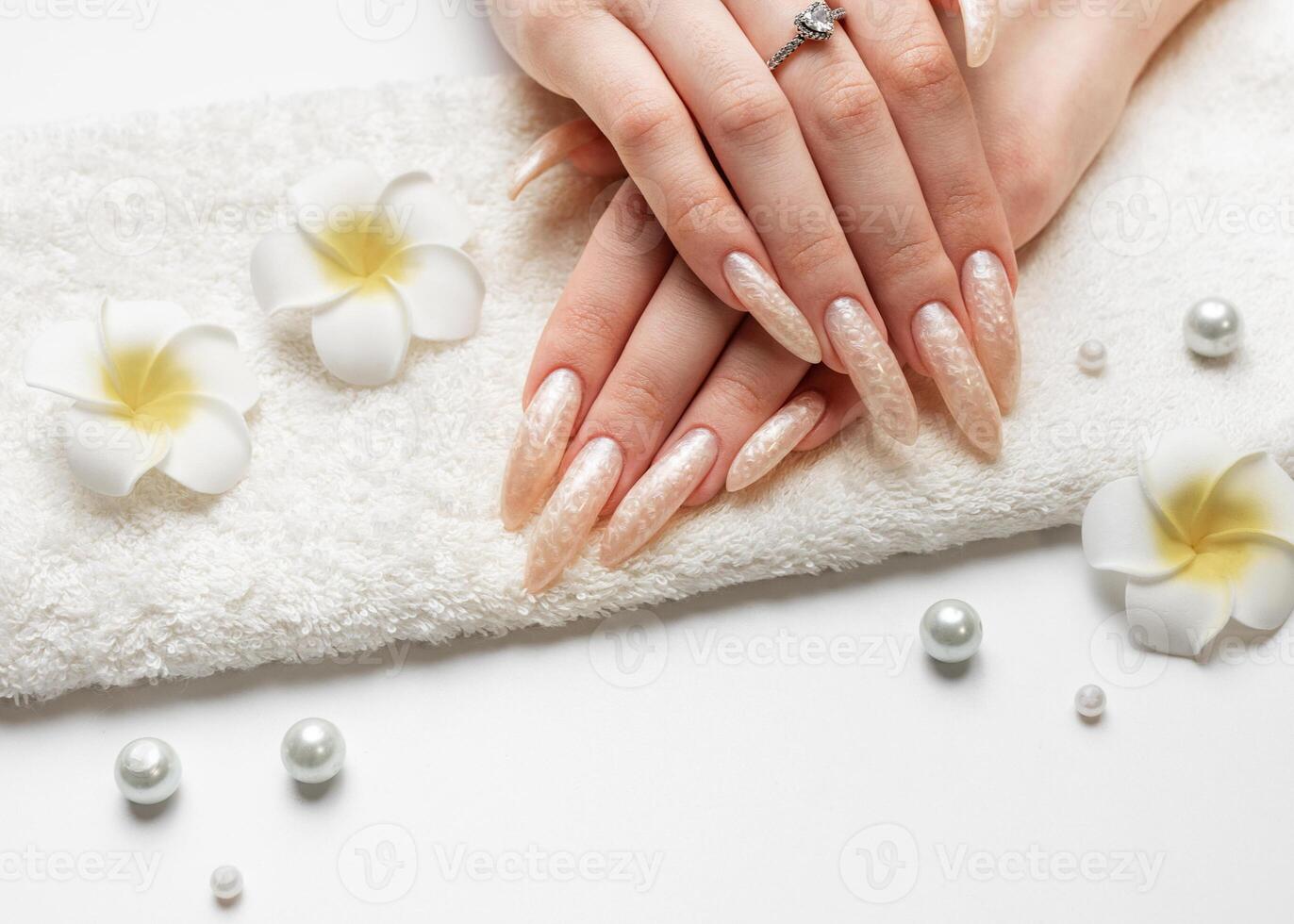 Hand of a young woman with white pearl  manicure photo