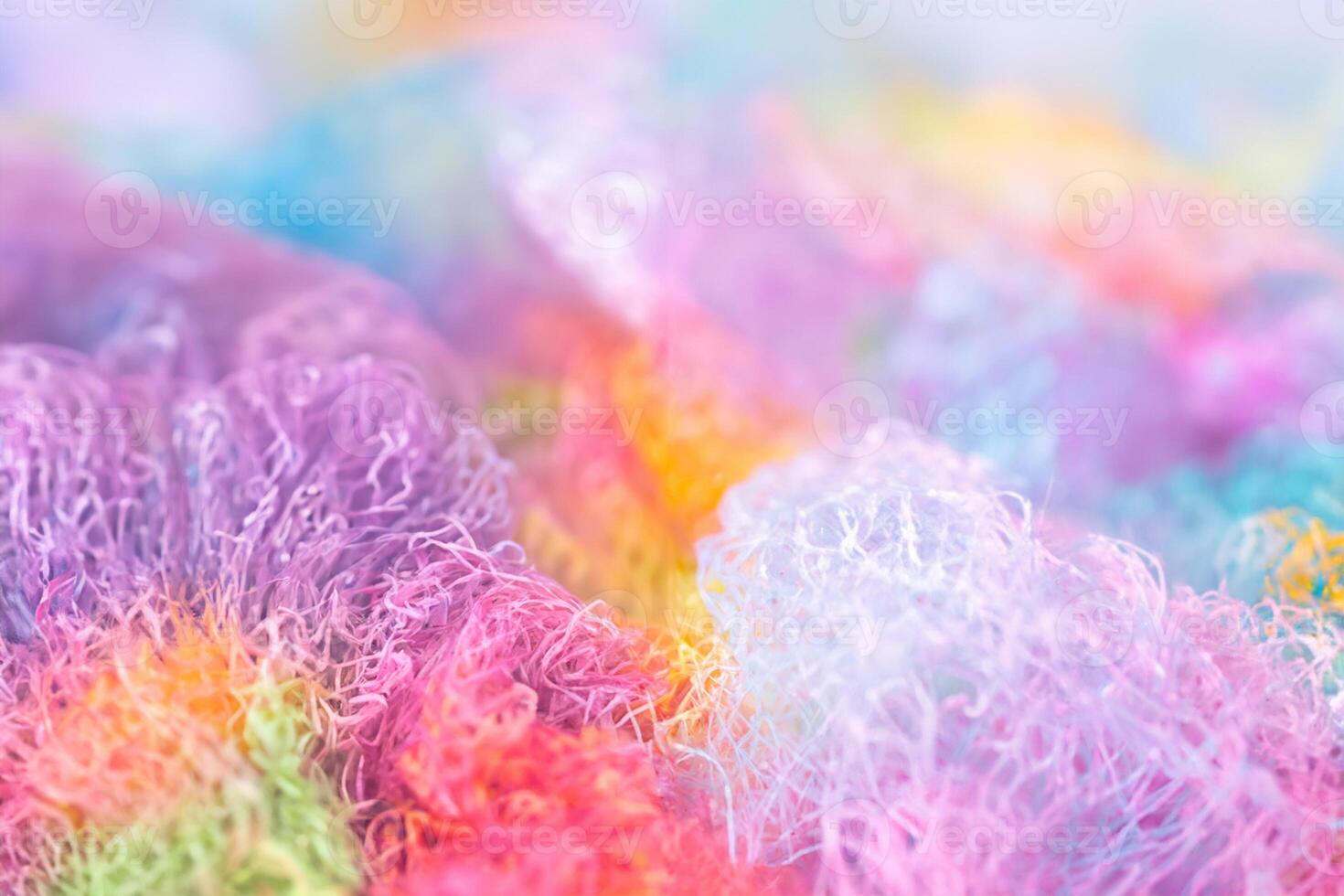 Knitted surface woolen items rainbow colored as a background. Closeup of soft multicolored knitted texture patterns. Warm winter clothes. Background textile surface with copy space for text. blurred photo