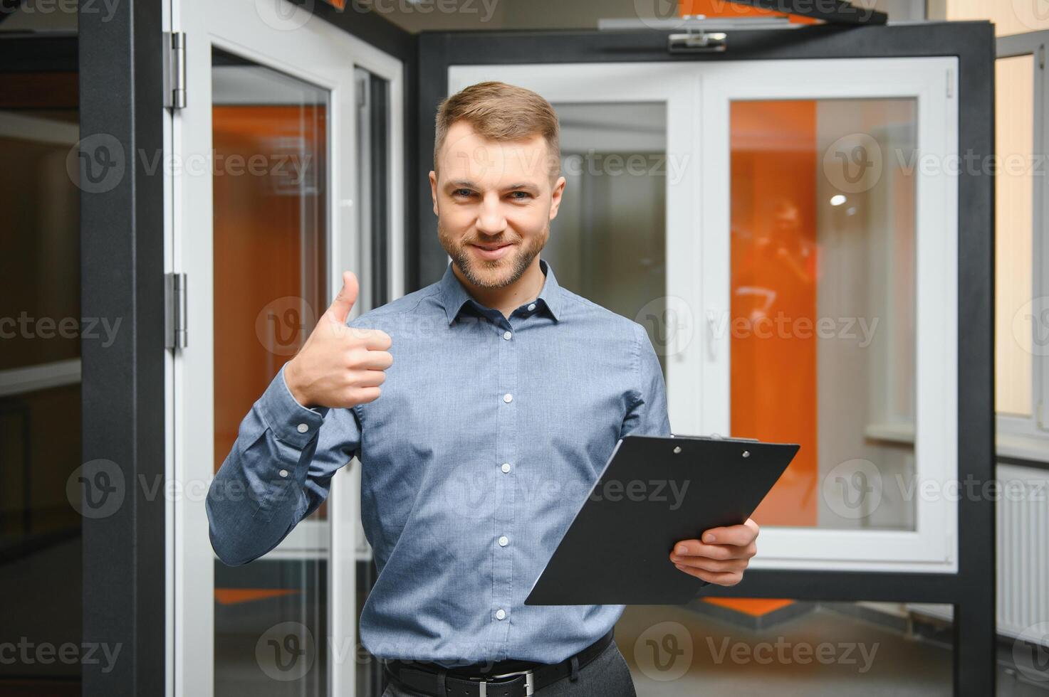 Friendly seller in window shop with keys. A large selection of windows and doors for the house. Home renovation concep photo