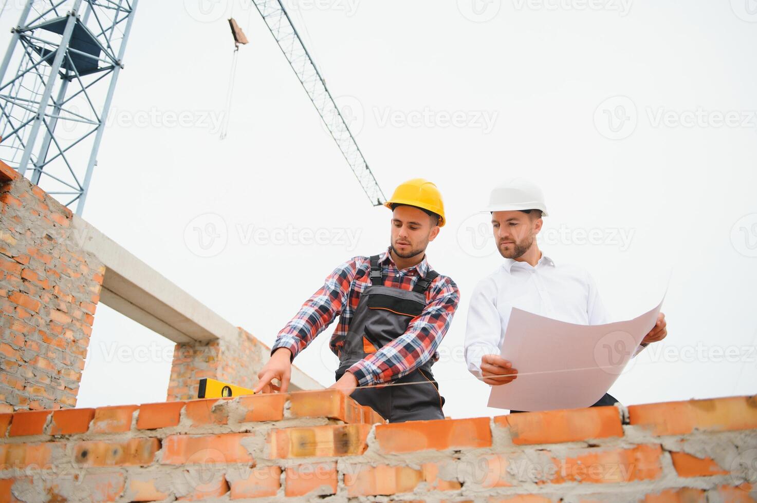 Builder and engineer on construction site photo