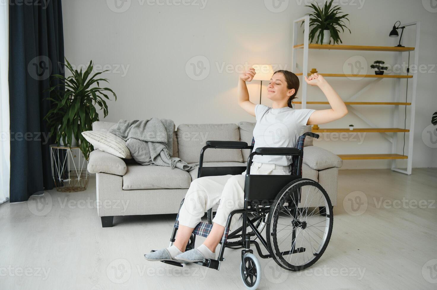 Woman in wheelchair working out in living room photo