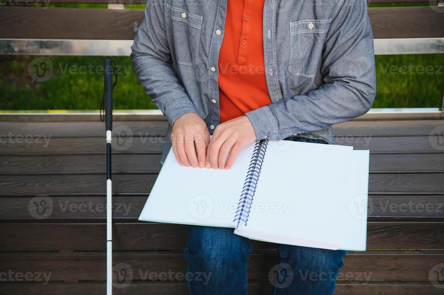 Blinded man reading by touching braille book photo