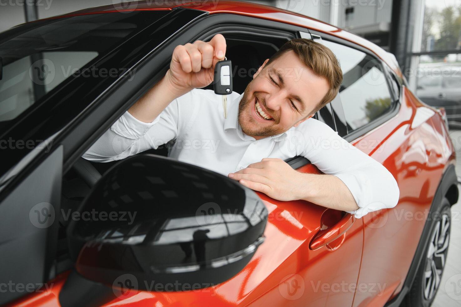 Handsome businessman driving car before buying photo