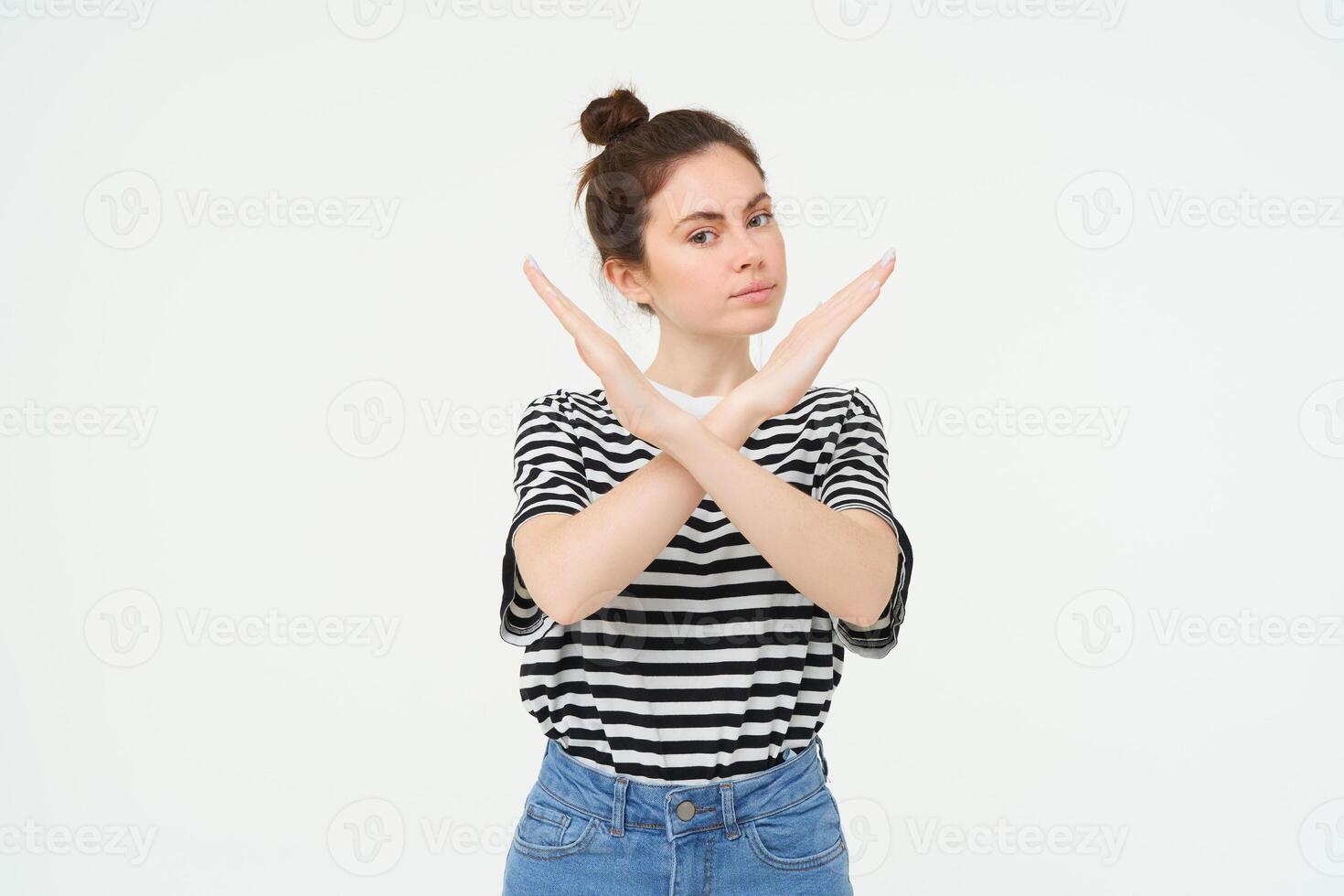 Portrait of confident young woman, showing cross sign, prohibit gesture, disapprove something, isolated against white background photo