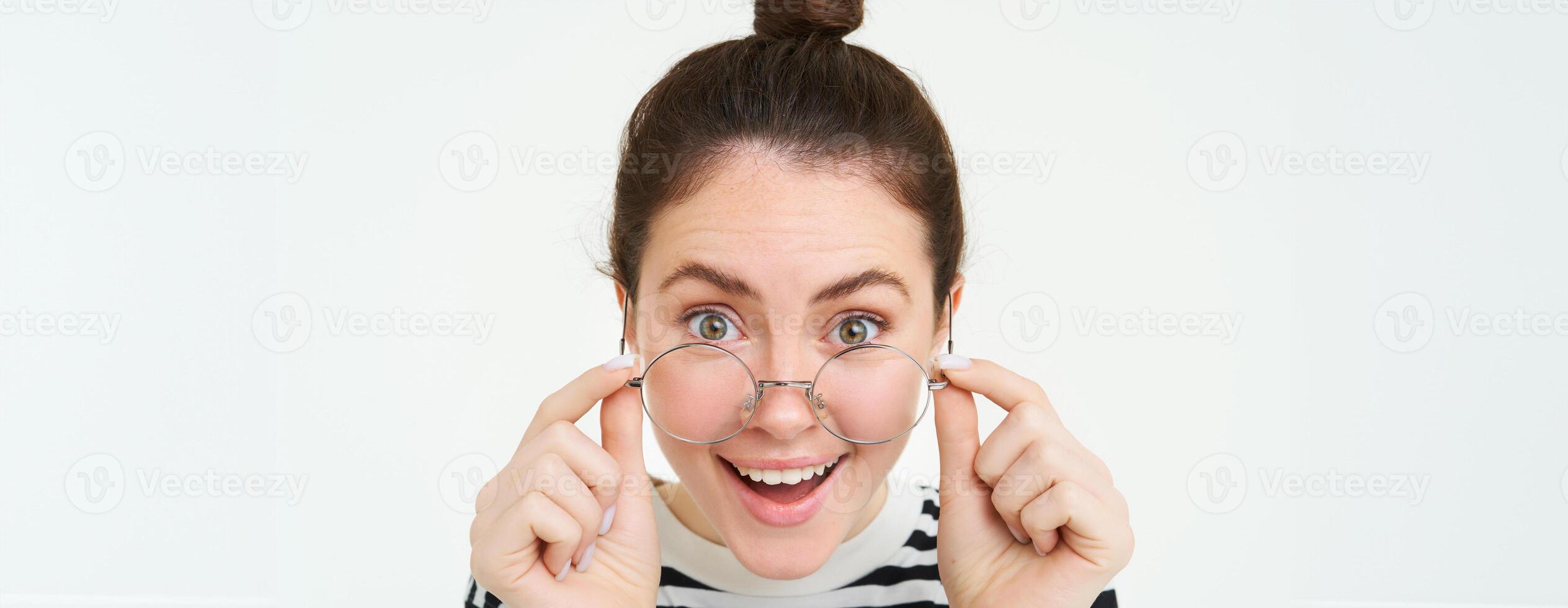 Close up portrait of woman with happy face, leaning towards camera as if reading amazing text, great news, wearing glasses, isolated over white background photo