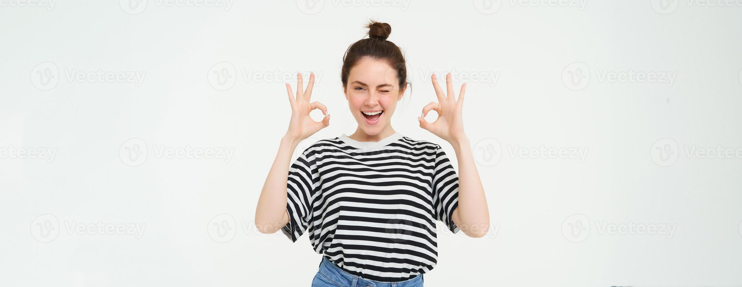 Excellent choice. Smiling stylish young woman, showing okay, ok gesture, zero sign, standing over white background photo