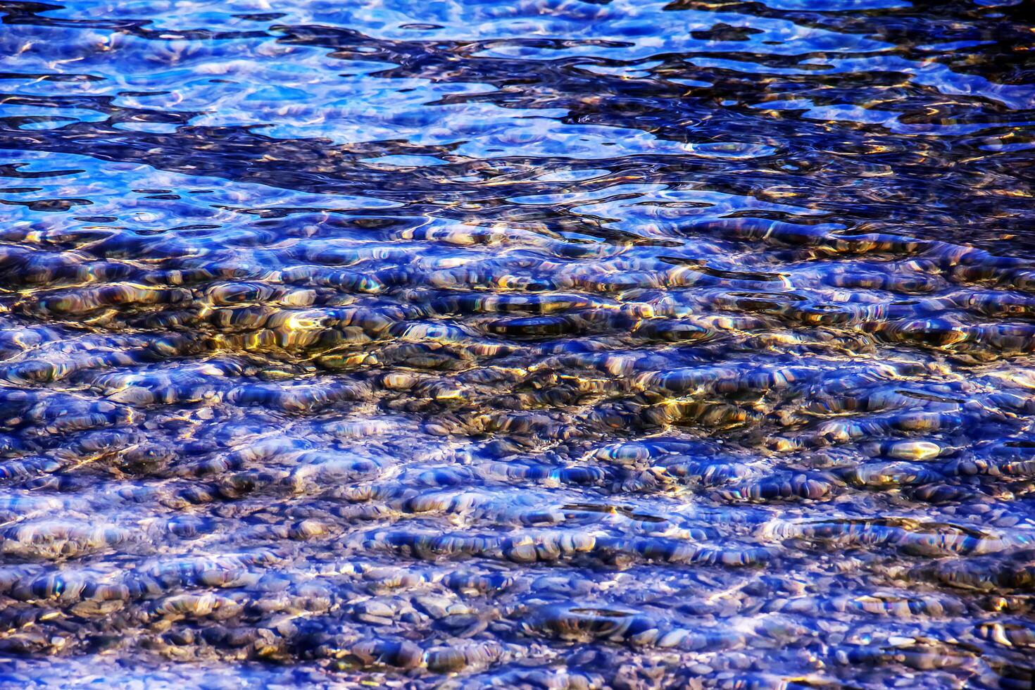 Background of the water of Lake Traunsee in the coastal area. Colorful texture of stones under water photo