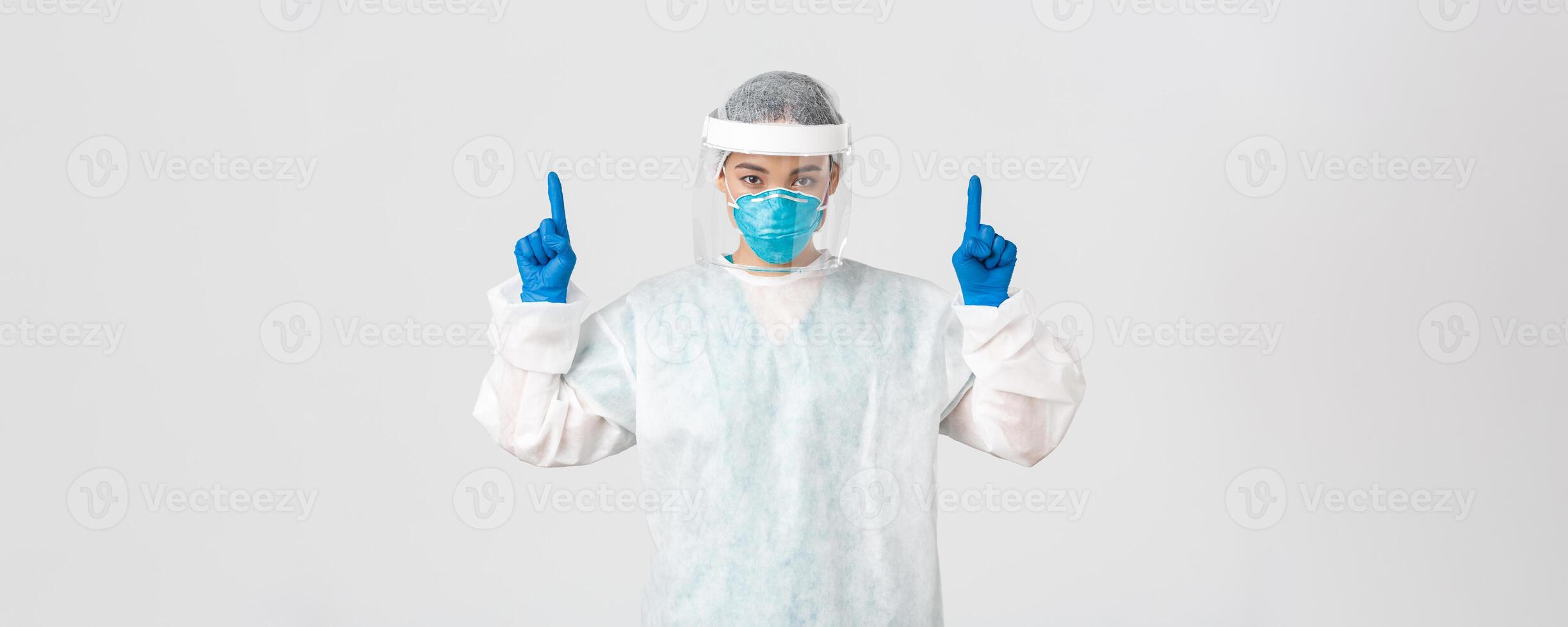 Covid-19, coronavirus disease, healthcare workers concept. Serious-looking young asian female doctor, tech lab employee in respirator and personal protective equipment, white background photo