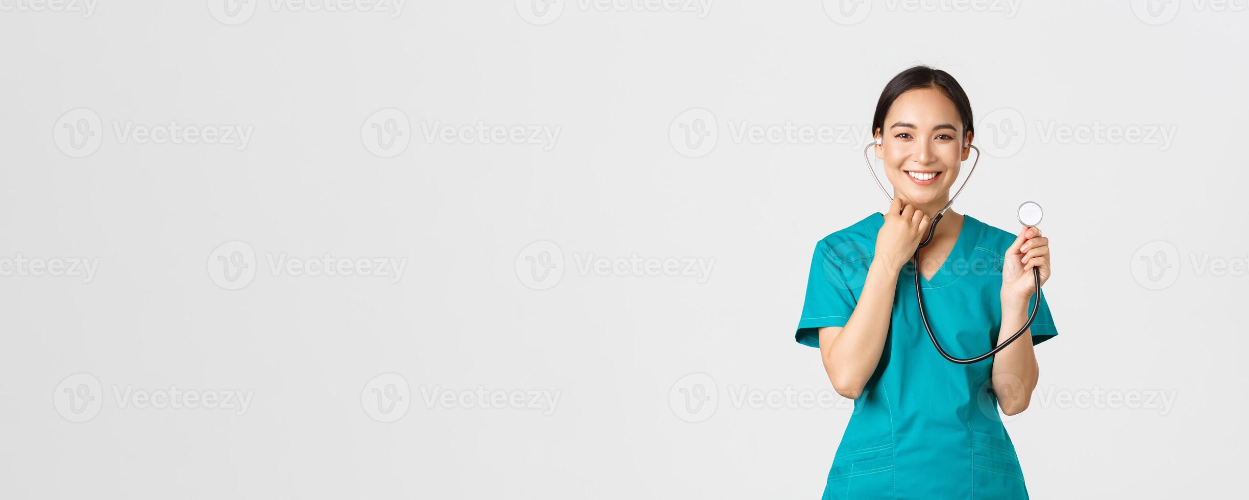 COVID-19, cuidado de la salud trabajadores y prevenir virus concepto. alegre sonriente asiático hembra médico, médico consultar paciente, examinar persona con estetoscopio, en pie blanco antecedentes foto