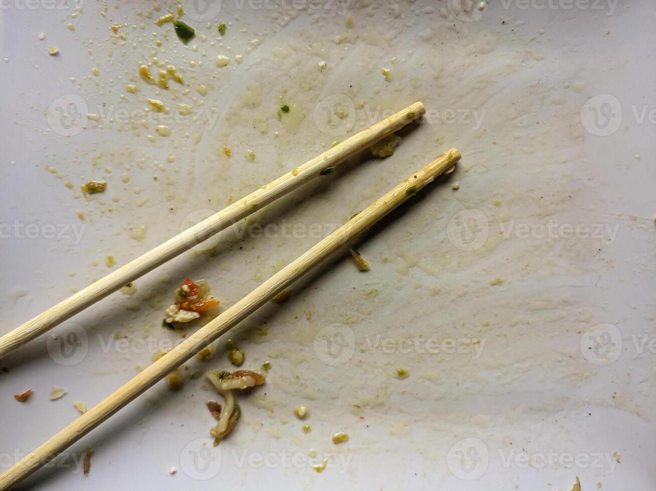 sucio vacío platos después comer y palillos después comiendo en lámina. foto