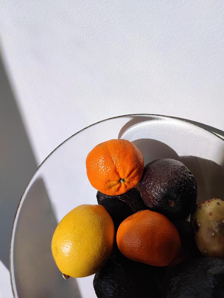 tropical frutas en un vaso florero. limón, palta, Mandarina y otro foto