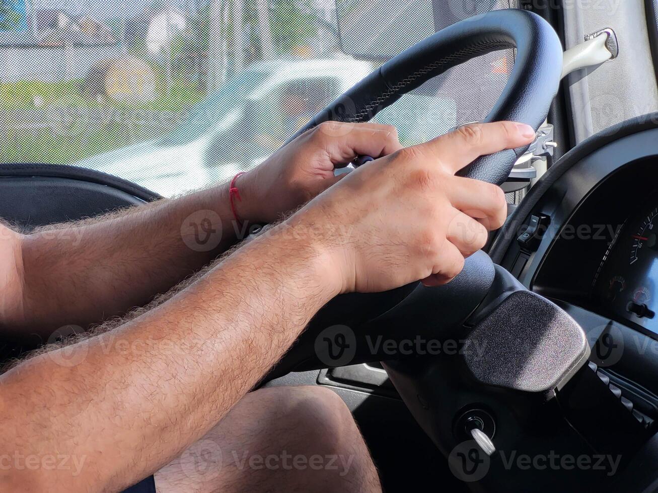 The driver's hands on the black steering wheel while driving photo