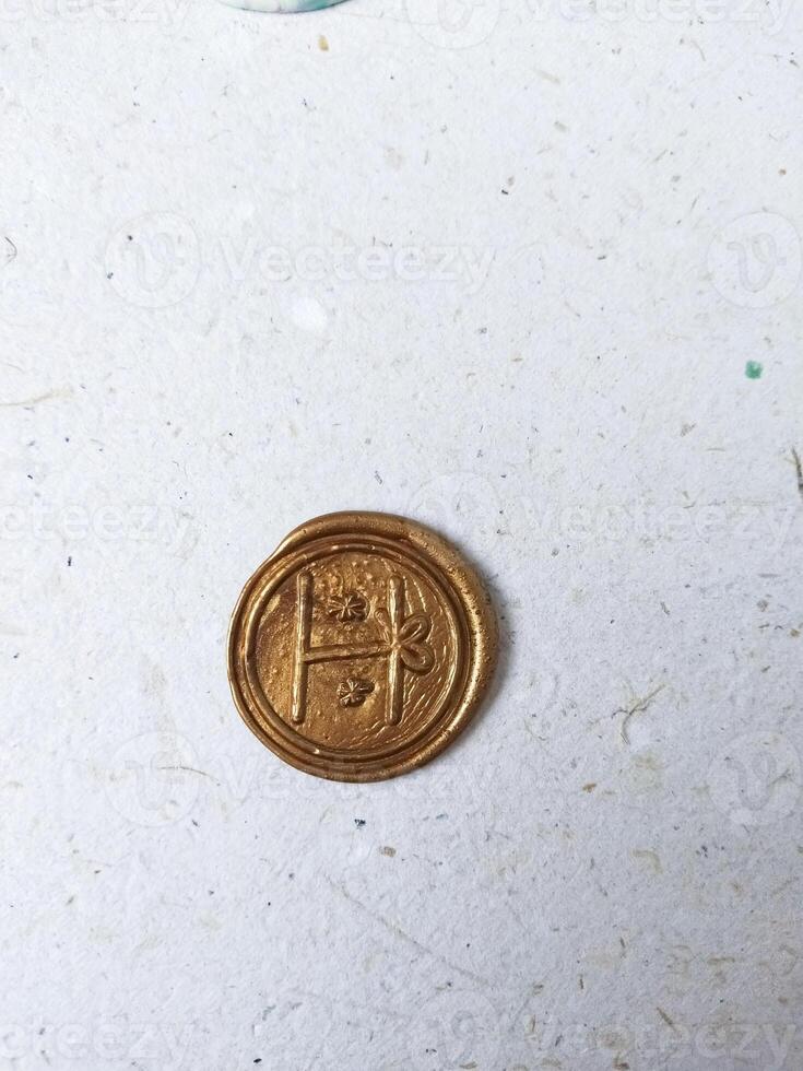 bronze wax coin on old paper background, top view, copy space photo