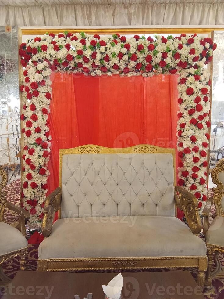 Paki Bahawalpuri wedding stage decoration yellow theme, stage decoration with multi color flowers, with flower theme arch decor, props and lights. photo