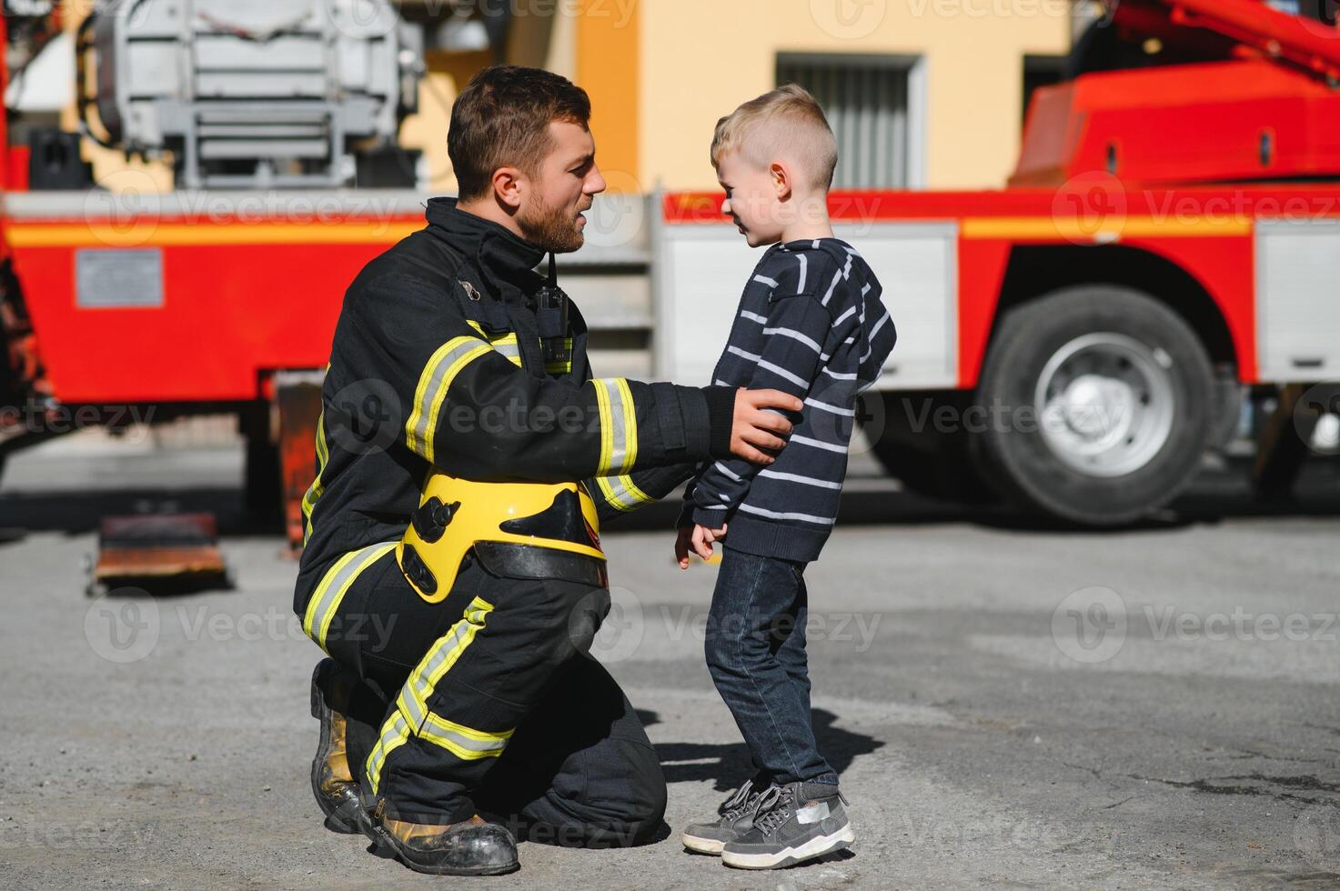 Firefighter holding child boy to save him in fire and smoke,Firemen rescue the boys from fire photo