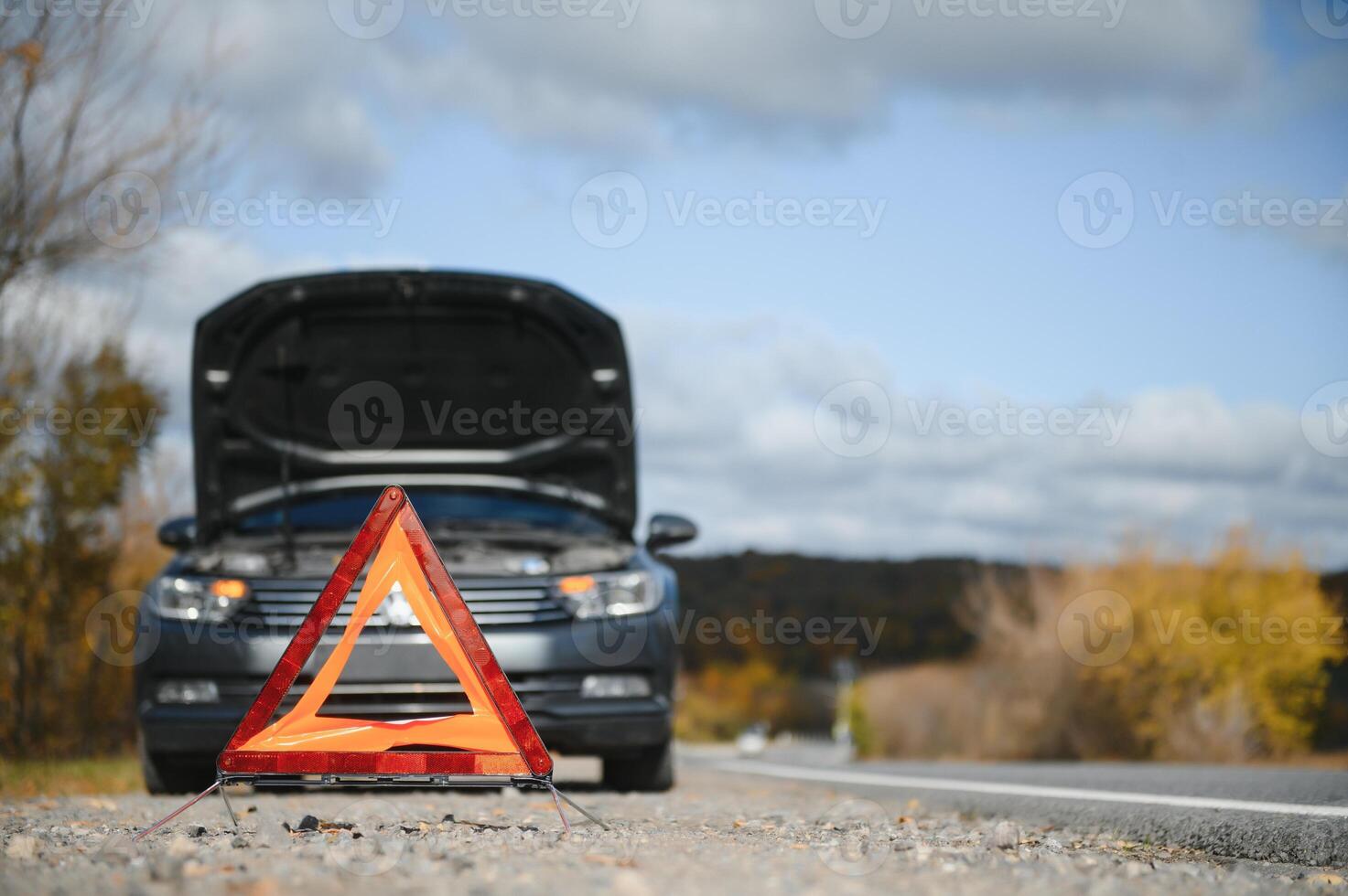 Descompostura triángulo soportes cerca un roto coche. foto