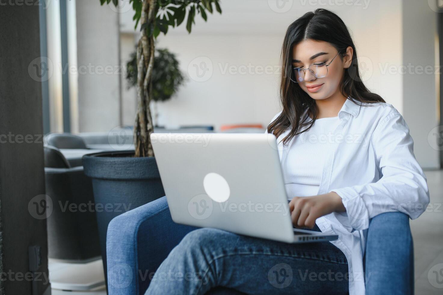 Beautiful Caucasian woman dreaming about something while sitting with portable net-book in modern cafe bar, young charming female freelancer thinking about new ideas during work on laptop computer photo