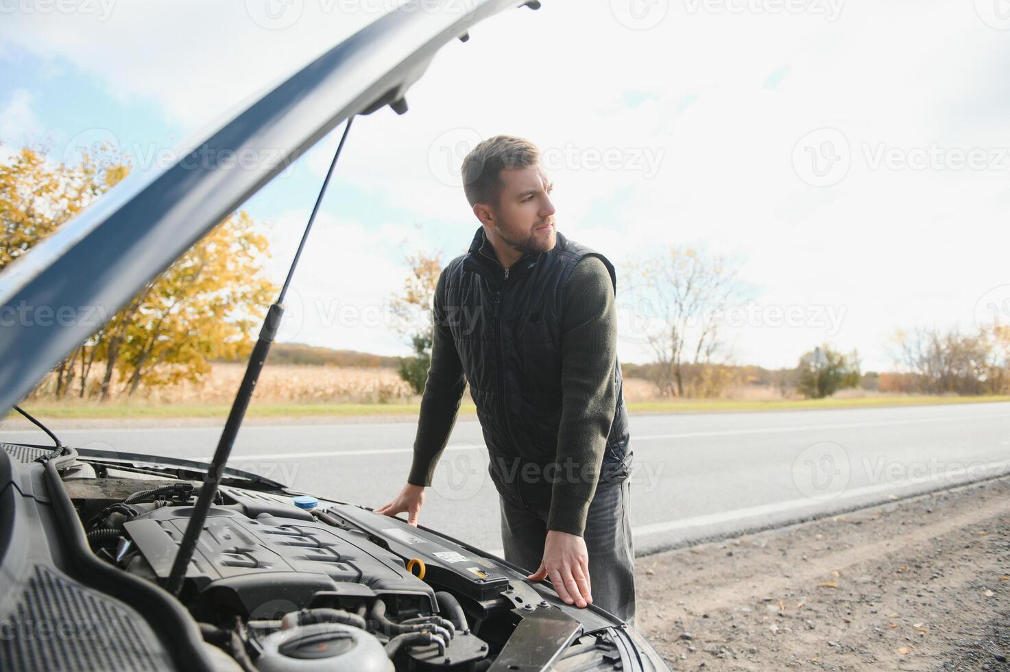 Man checking his broke down car photo