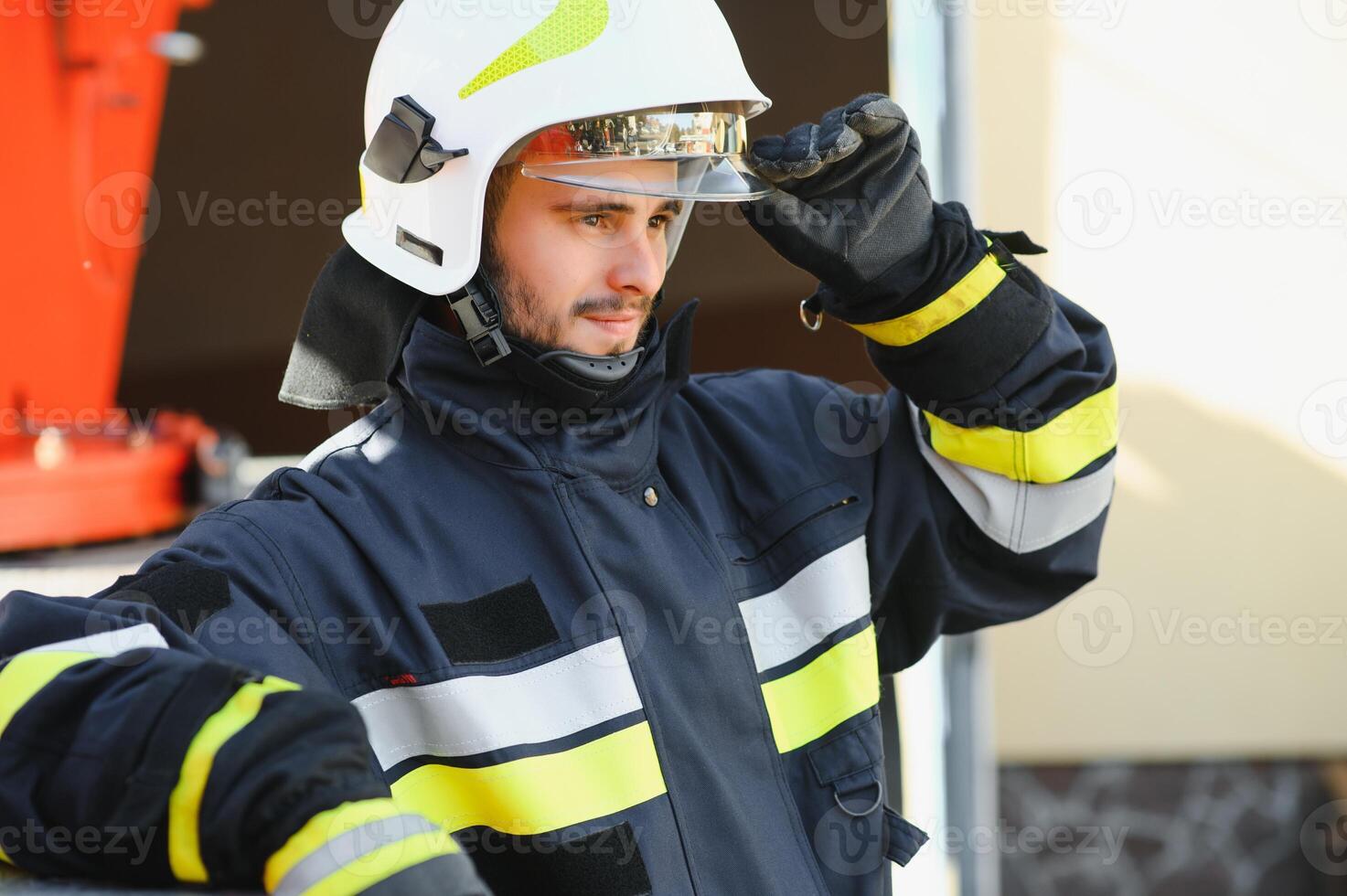 Firefighter portrait on duty. Photo fireman with gas mask and helmet near fire engine.