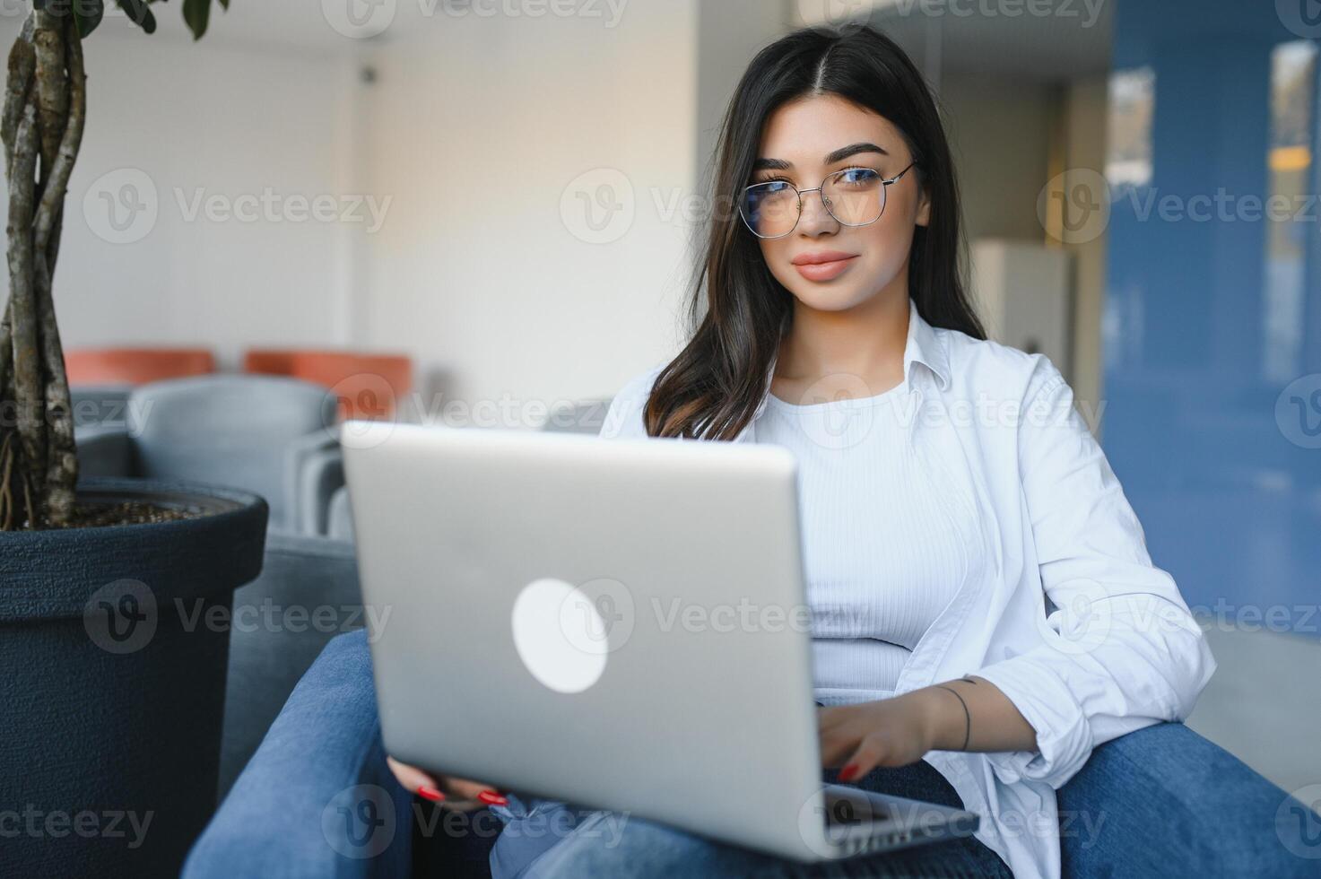 Joyful girl student studying online at cafe, using laptop and earphones, empty space photo